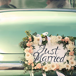 bride and groom leaving in a classic car